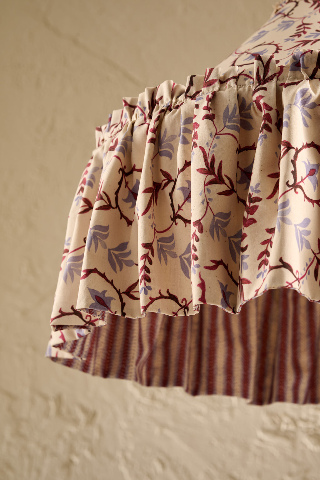 A close-up of  Daunder Dusty Sky and Merlot Statement Rufffle lampshade showing the frill hem detail and contrast lining 