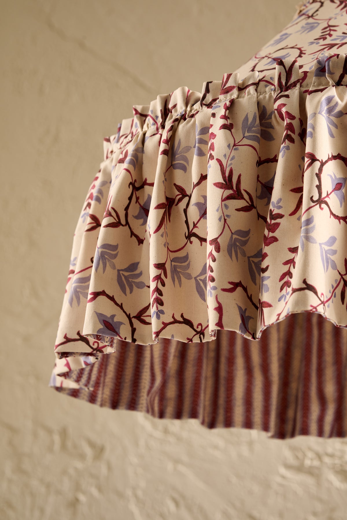 A close-up of  Daunder Dusty Sky and Merlot Statement Rufffle lampshade showing the frill hem detail and contrast lining 