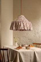 Daunder Ruffle Statement Lampshade in Merlot & Dusty Blue hanging above a dining table in a warm neutral interior