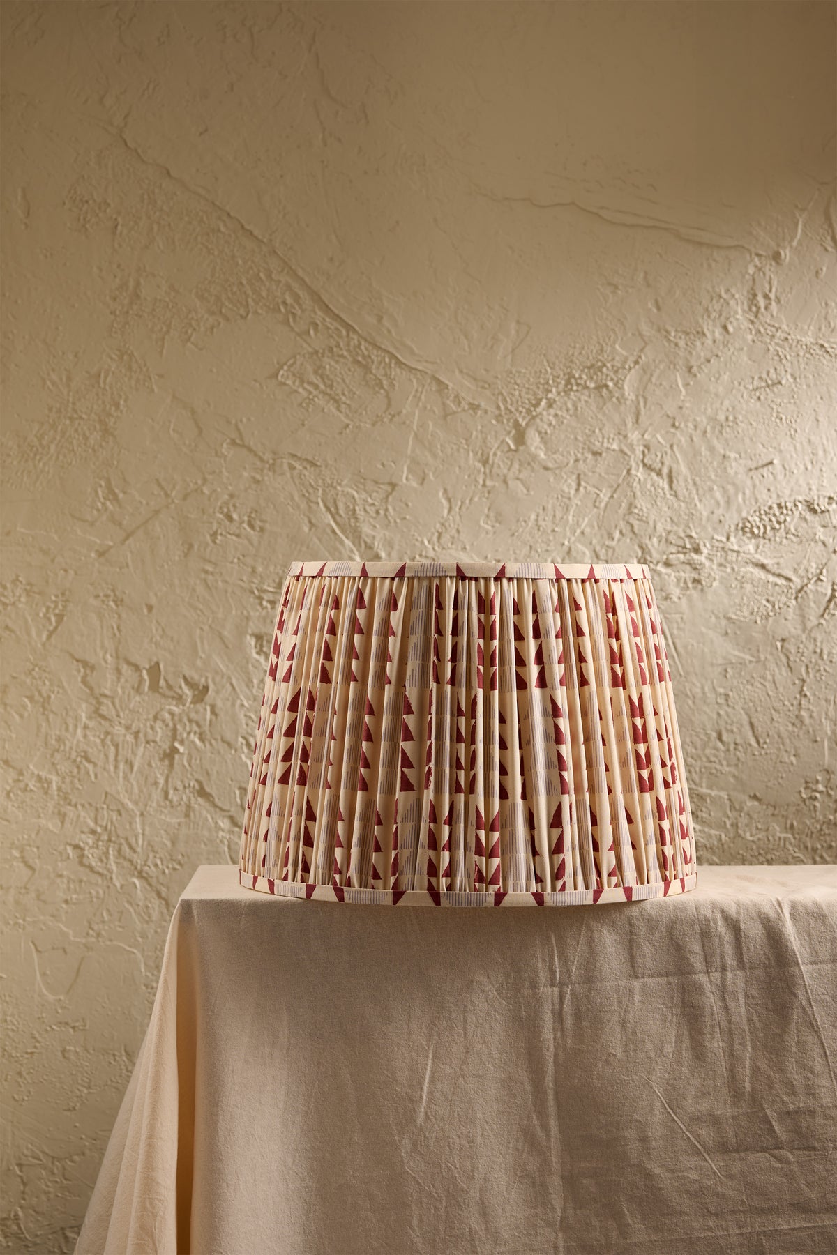 Ellis pleated lampshade in Merlot showing the hand-block printed geometric pattern in red and soft blue-grey