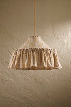 Ellis Ruffle Statement Lampshade in Dusty Sky & Ochre hanging in front of a textured wall showing the contrasting geometric lining