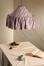 Ellis Ruffle Statement Lampshade in Dusty Blue & Merlot hanging above a dining table in a warm neutral interior