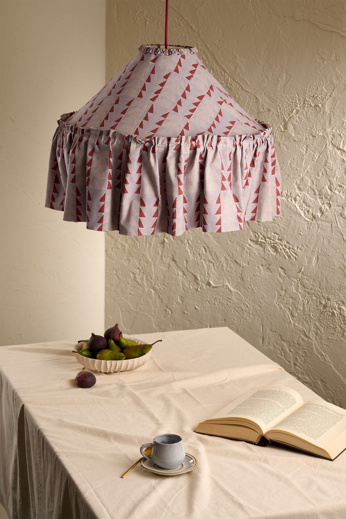 Ellis Ruffle Statement Lampshade in Dusty Blue & Merlot hanging above a dining table in a warm neutral interior